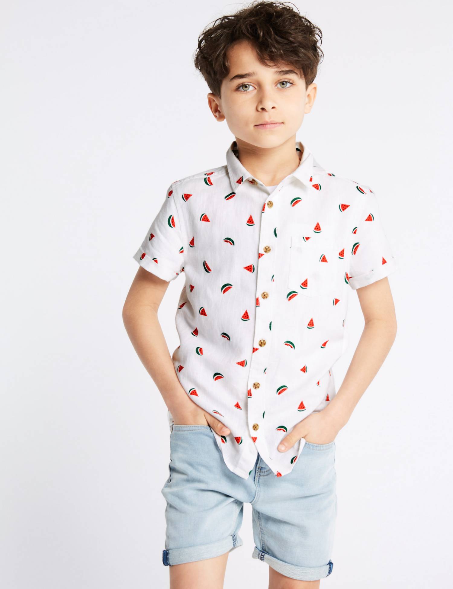 Child wearing a watermelon-print shirt with light-wash denim shorts