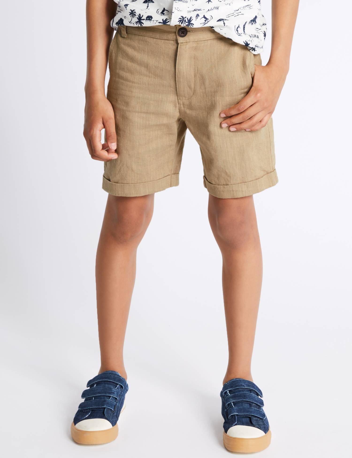 Child wearing khaki cuffed shorts with a navy palm-print shirt and denim sneakers