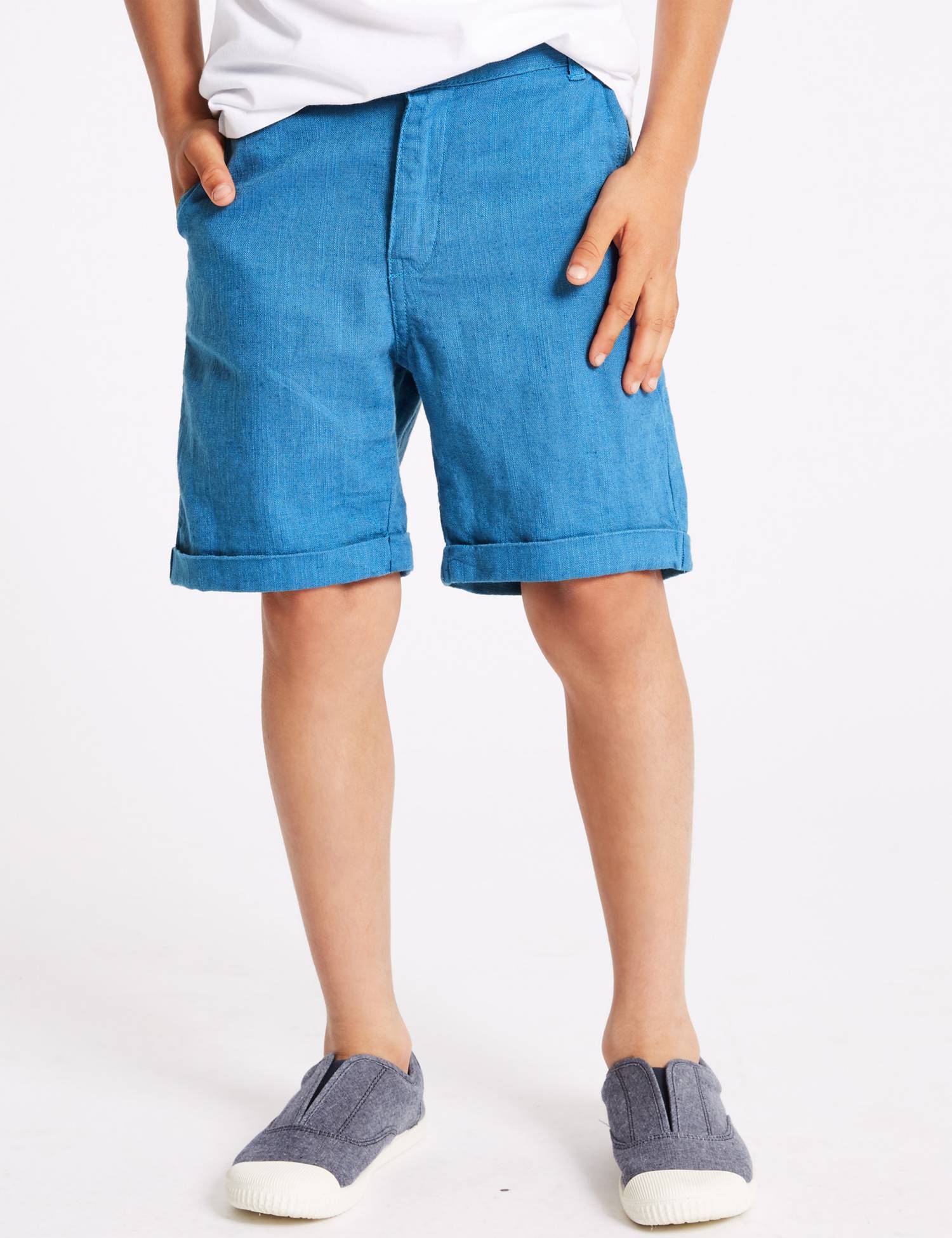 Child wearing mid-blue cuffed shorts with a white T-shirt and canvas slip-ons