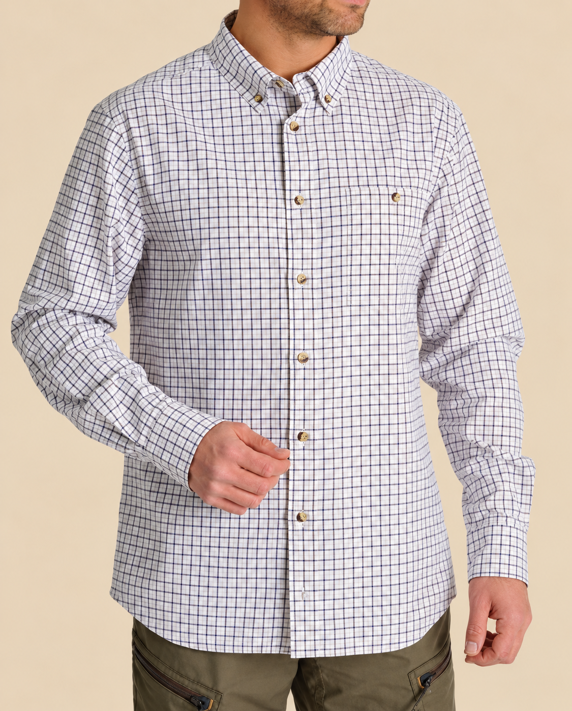 Model wearing a navy and brown gingham long-sleeve shirt with olive trousers
