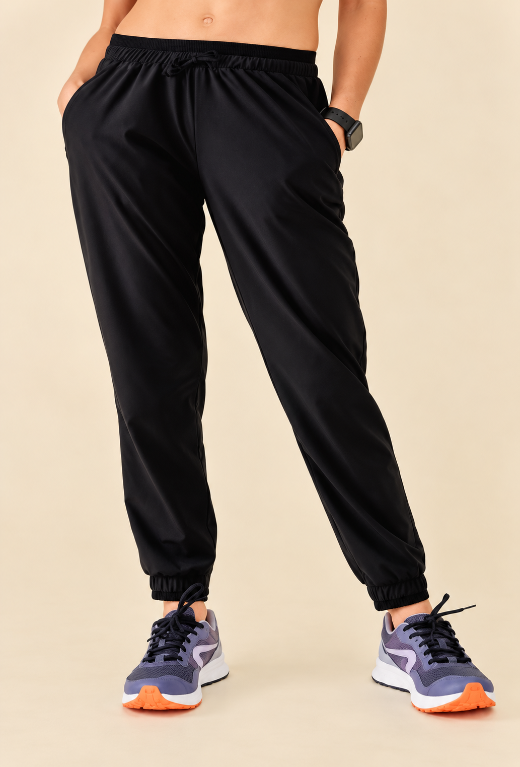 Model wearing black cuffed athletic joggers with lavender sneakers