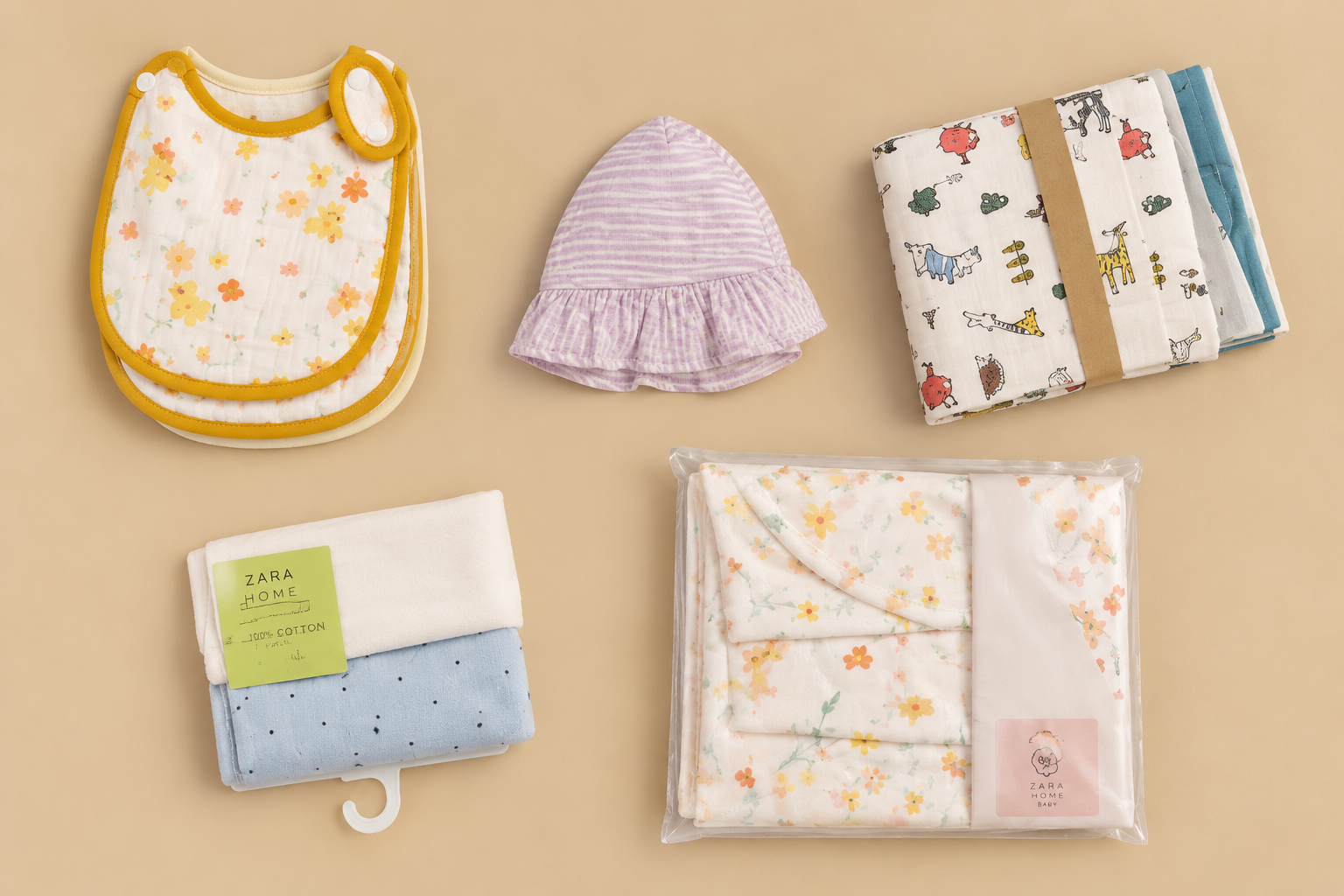 Curated baby accessories flat lay — bibs, hat, cloths and blanket